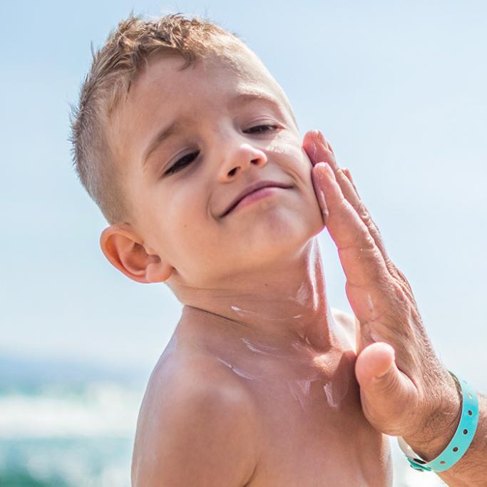 petit garçon avec de la crème solaire